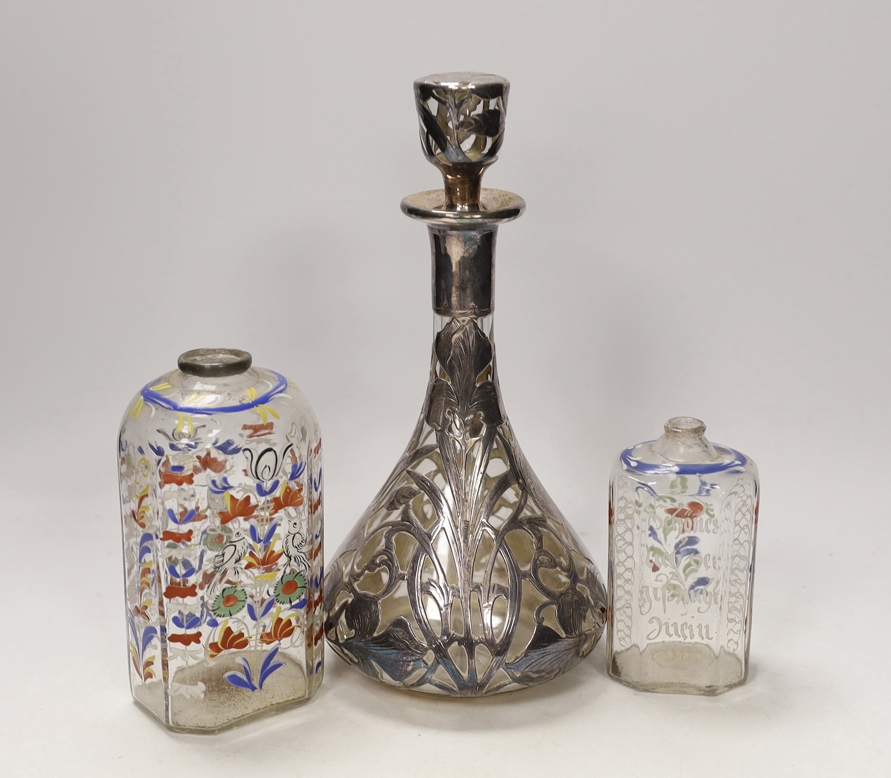 An Art Nouveau white metal jacketed decanter, together with a pair of German enamelled glass flasks, tallest 25cm (3)